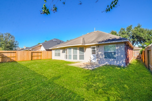 rear view of house featuring a patio area and a yard