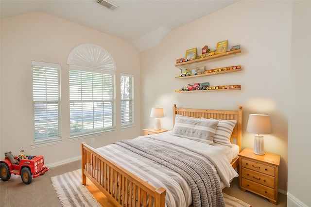 bedroom with light colored carpet and vaulted ceiling