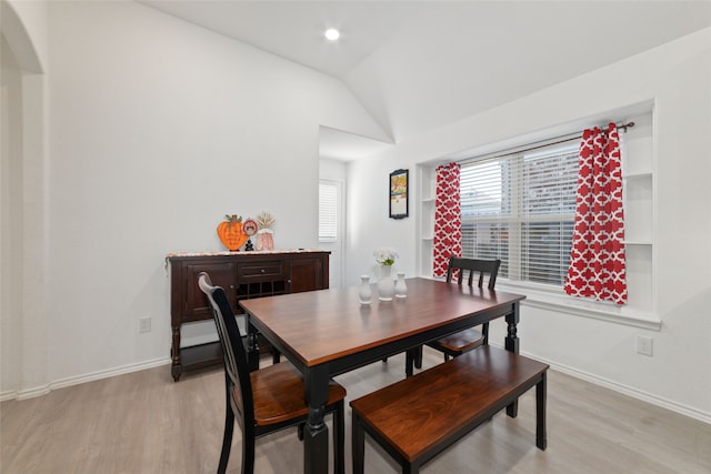 dining area featuring light hardwood / wood-style flooring and vaulted ceiling