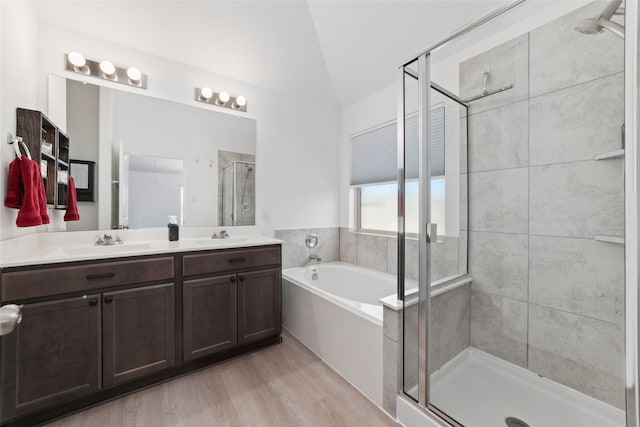 bathroom with hardwood / wood-style flooring, vanity, lofted ceiling, and independent shower and bath