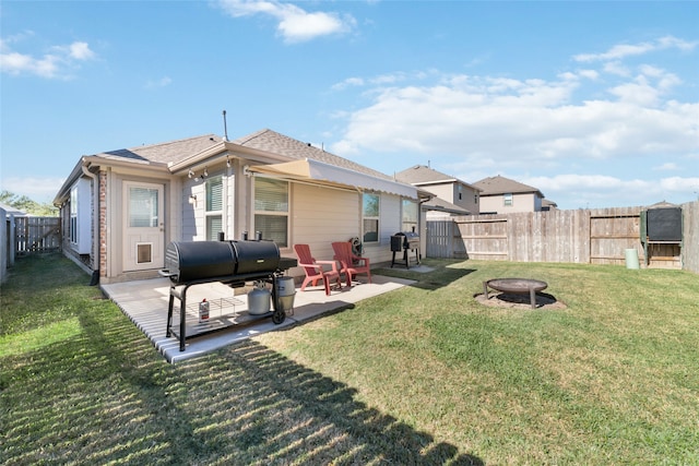 back of house featuring a patio, an outdoor fire pit, and a lawn