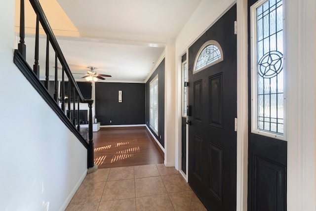 foyer featuring hardwood / wood-style flooring, ceiling fan, ornamental molding, and a wealth of natural light