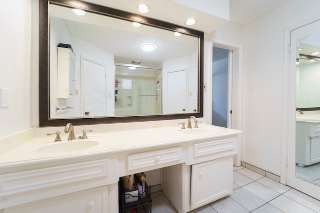 bathroom featuring tile patterned flooring, vanity, and a shower with door