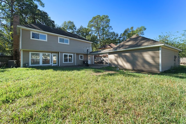 back of property featuring a yard and central air condition unit