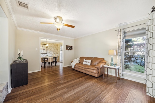 living room featuring a textured ceiling, ceiling fan, ornamental molding, and dark wood-type flooring