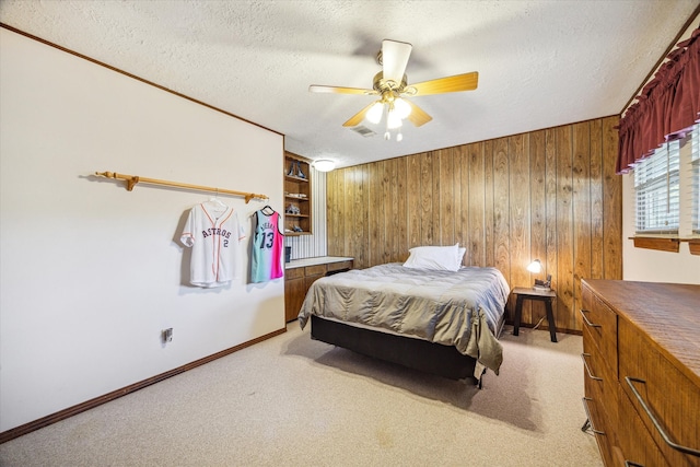 carpeted bedroom with a textured ceiling, ceiling fan, and wooden walls