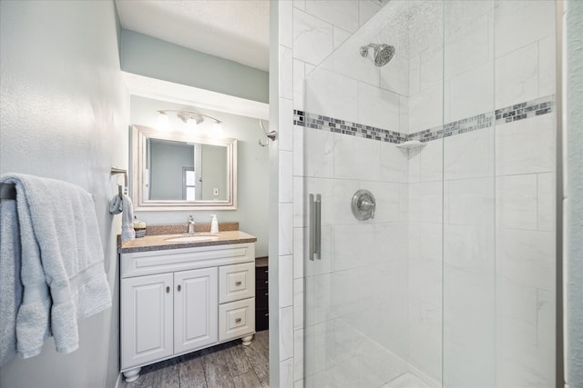 bathroom featuring hardwood / wood-style floors, vanity, and a shower with shower door