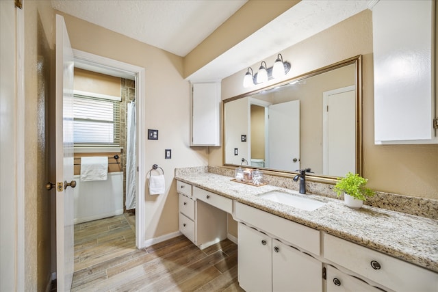 bathroom featuring hardwood / wood-style floors, vanity, and a textured ceiling