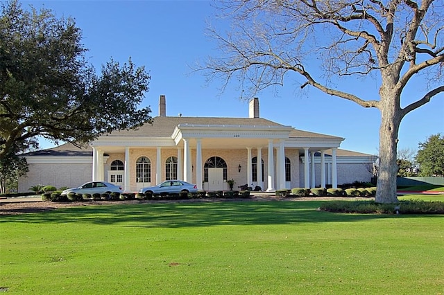 greek revival inspired property featuring a porch and a front yard