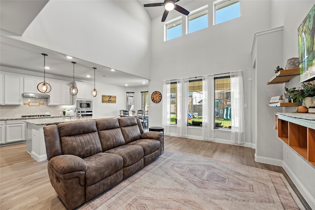 living room featuring ceiling fan, a healthy amount of sunlight, and light hardwood / wood-style flooring