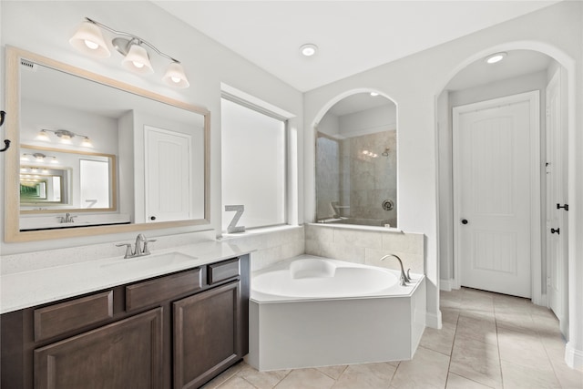 bathroom with tile patterned flooring, vanity, and independent shower and bath