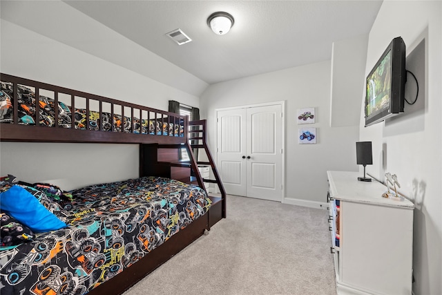 carpeted bedroom featuring vaulted ceiling and a closet