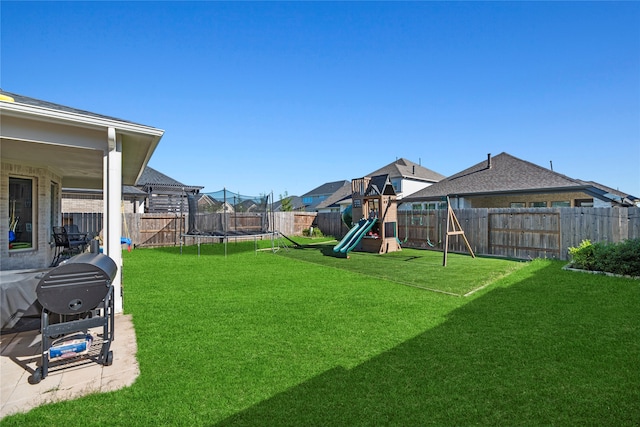 view of yard with a playground, a trampoline, and a patio area