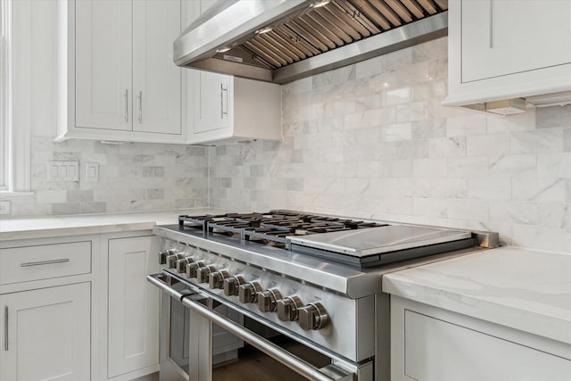 7523 Cuadro Ln, Houston, TX 77055 - kitchen with high end stainless steel range, wall chimney exhaust hood, decorative backsplash, and light stone counters