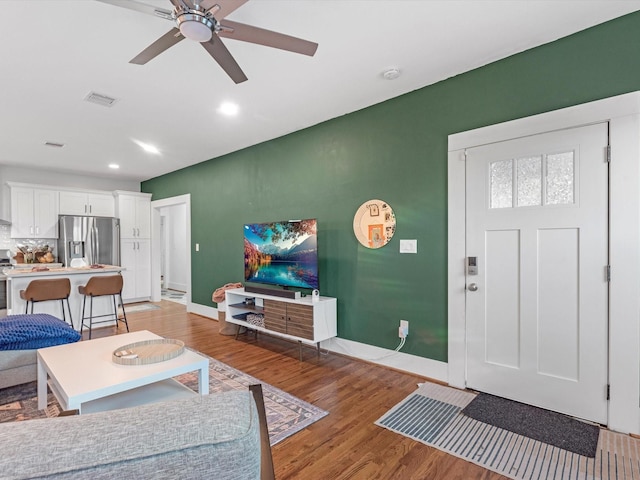 living room with light hardwood / wood-style flooring and ceiling fan