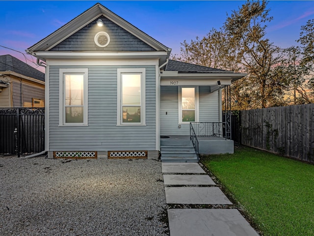 view of front facade featuring covered porch and a lawn