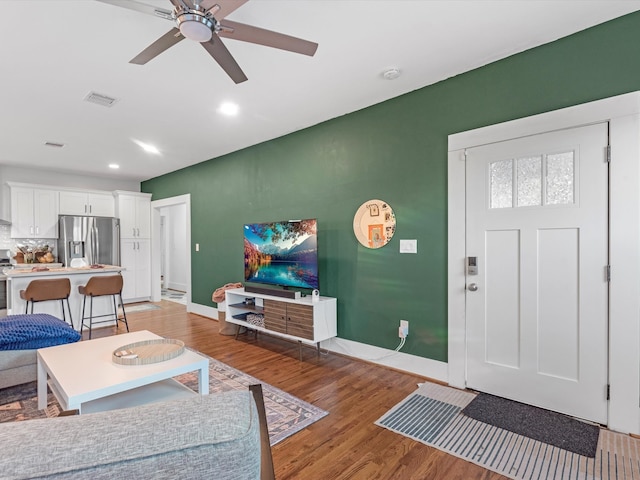 living room featuring ceiling fan and light hardwood / wood-style floors