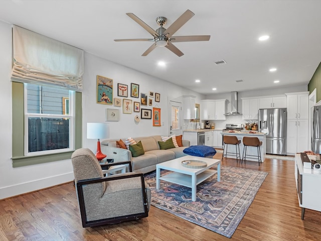 living room with ceiling fan and light hardwood / wood-style floors