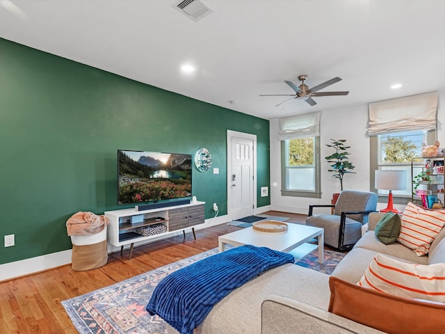 living room featuring wood-type flooring and ceiling fan