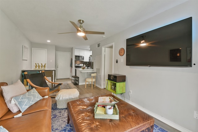 living room with ceiling fan and hardwood / wood-style floors