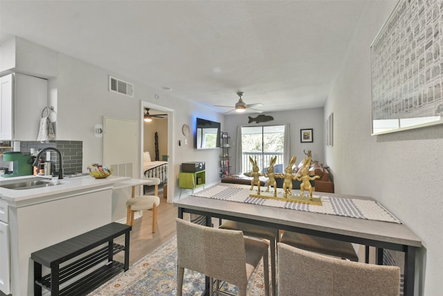 dining room featuring light hardwood / wood-style flooring, ceiling fan, and sink