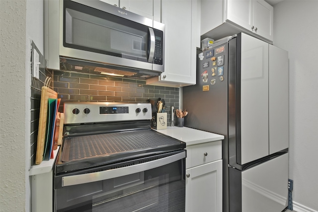 kitchen featuring decorative backsplash, white cabinets, and stainless steel appliances