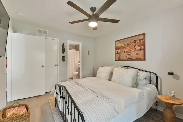 bedroom featuring light wood-type flooring, ensuite bathroom, and ceiling fan