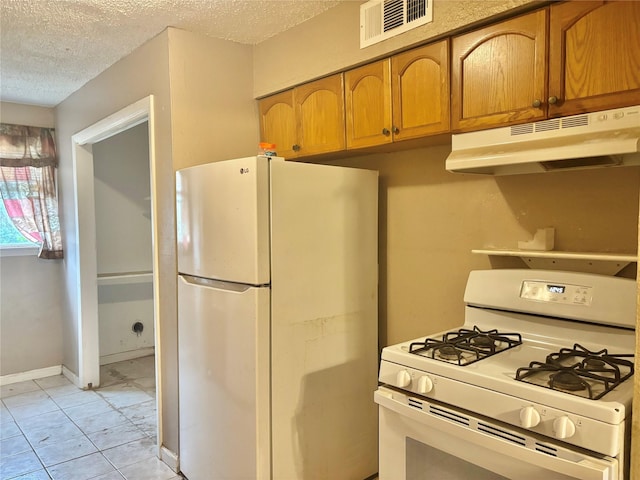 kitchen with a textured ceiling and white appliances