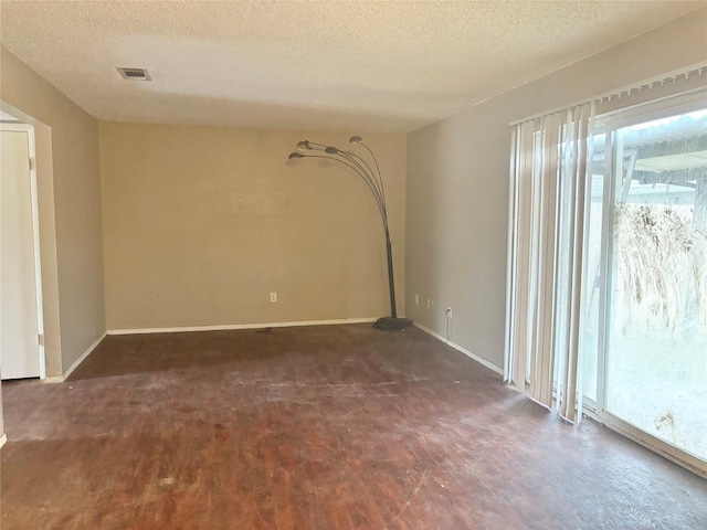 spare room with dark hardwood / wood-style flooring and a textured ceiling