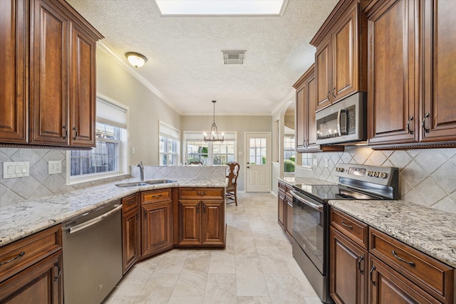 kitchen featuring tasteful backsplash, a chandelier, decorative light fixtures, and appliances with stainless steel finishes