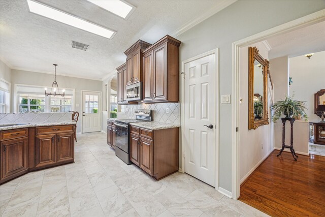 kitchen with light stone countertops, tasteful backsplash, a textured ceiling, stainless steel appliances, and crown molding