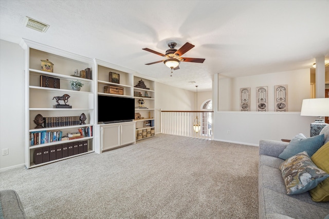 living room featuring carpet, a textured ceiling, and ceiling fan