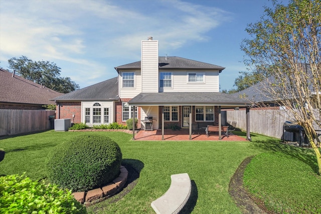 rear view of house with a lawn, a patio area, and central AC