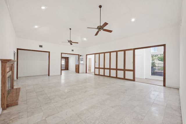 unfurnished living room with ceiling fan and high vaulted ceiling