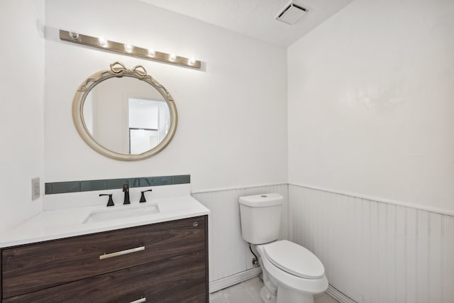 bathroom featuring vanity, toilet, and a textured ceiling