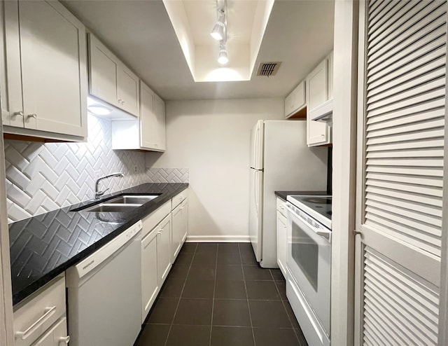 kitchen with white cabinetry, sink, a raised ceiling, backsplash, and white appliances