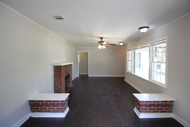 unfurnished living room with a fireplace, dark hardwood / wood-style flooring, ceiling fan, and crown molding