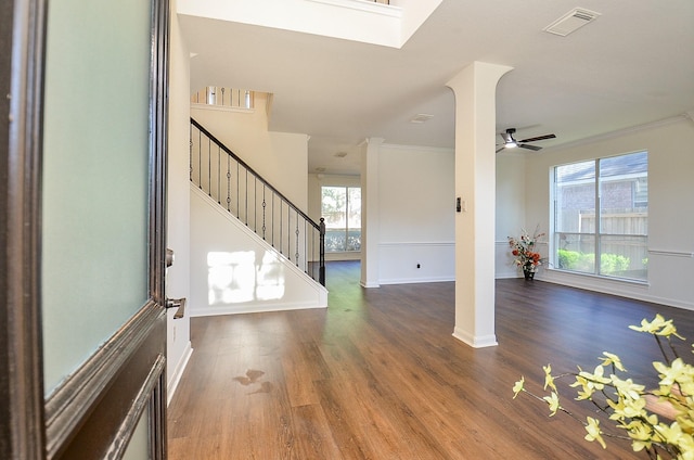 foyer entrance with crown molding, dark wood-type flooring, and ceiling fan