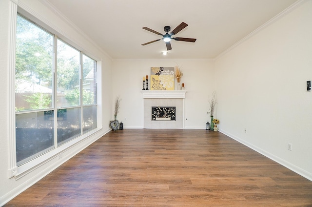 unfurnished living room with dark hardwood / wood-style flooring, crown molding, a wealth of natural light, and a tile fireplace