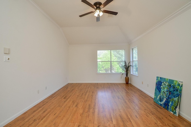 spare room with vaulted ceiling, ornamental molding, ceiling fan, and light wood-type flooring