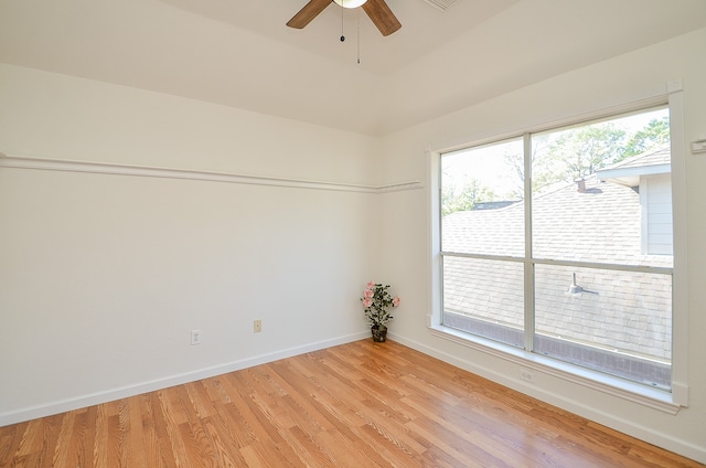 empty room with ceiling fan, plenty of natural light, and light hardwood / wood-style floors