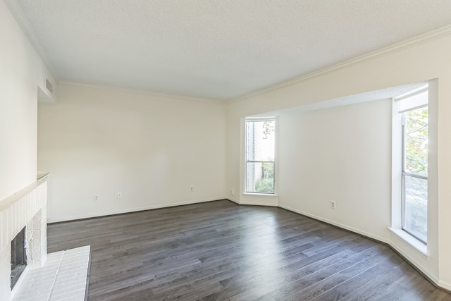 unfurnished living room with visible vents, dark wood finished floors, crown molding, a textured ceiling, and a brick fireplace