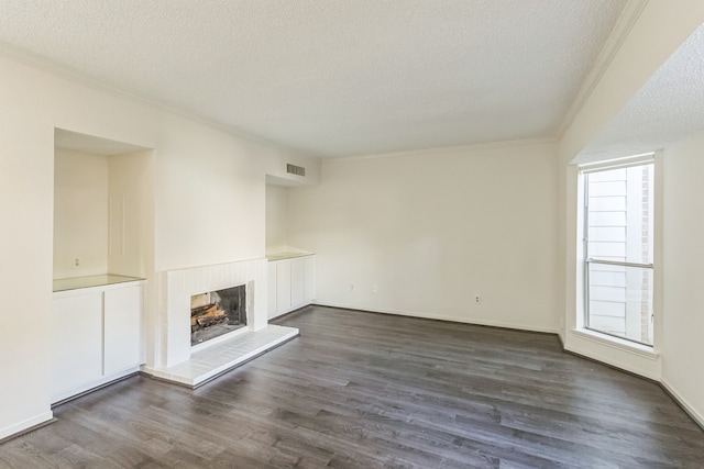 unfurnished living room with dark hardwood / wood-style flooring, a textured ceiling, and ornamental molding