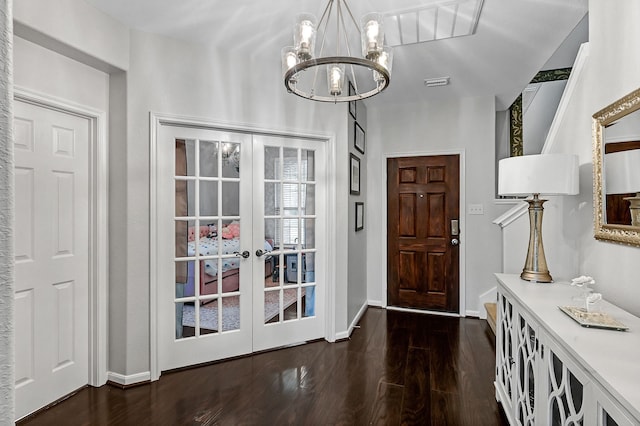 entrance foyer featuring an inviting chandelier, dark wood-type flooring, and french doors