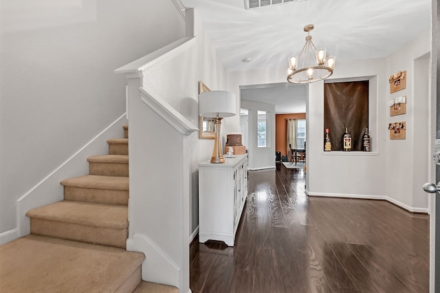 entrance foyer featuring dark hardwood / wood-style flooring and a chandelier