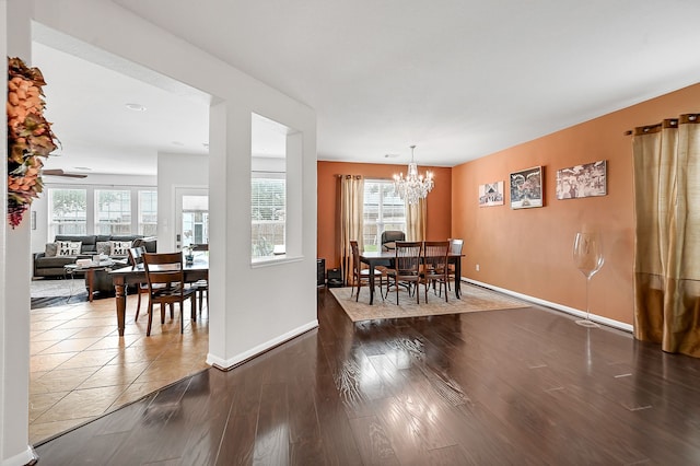 dining room with dark hardwood / wood-style flooring, a wealth of natural light, and a notable chandelier