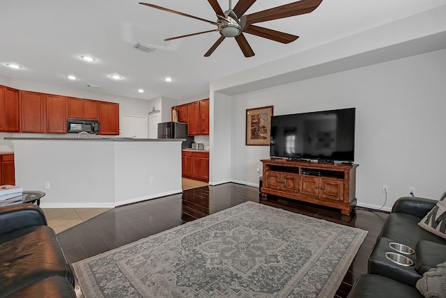 living room with ceiling fan and dark wood-type flooring