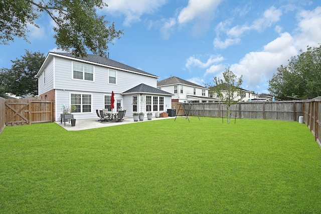 back of house featuring a patio area and a lawn