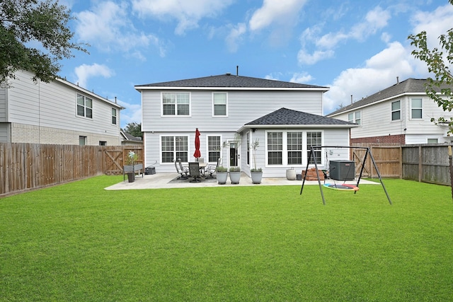 rear view of house with a lawn, central air condition unit, and a patio