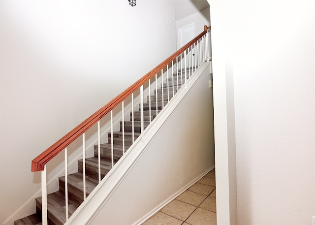 stairway featuring tile patterned flooring